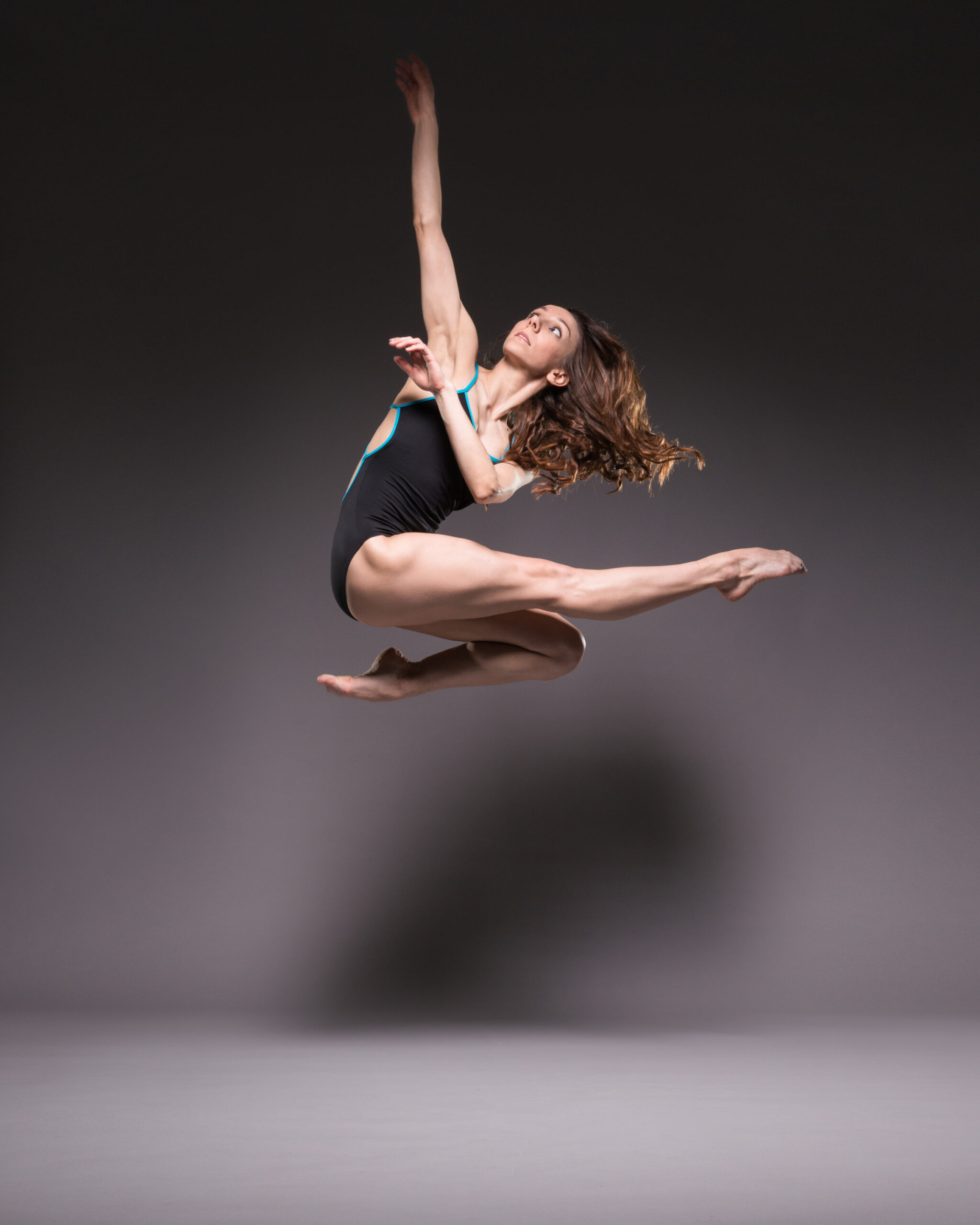 Kate Lyons performing a parallel jump, dance studio Photography by ASH